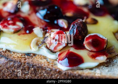 Bread toast with butter, roasted hazelnuts, honey, berry jam on plate ...