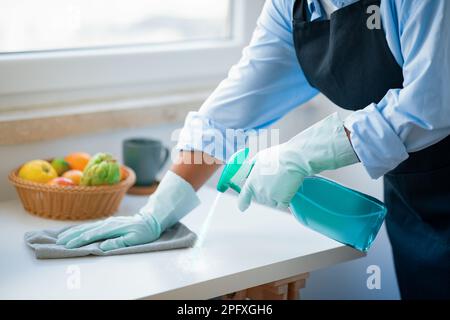 Unrecognizable maid hands cleaning kitchen, house-keeping service concept Stock Photo