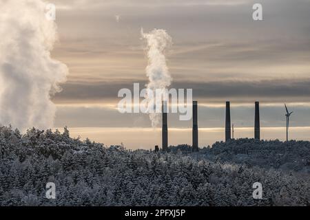 Steam rising from industrial buildings beyond frozen forests Stock ...