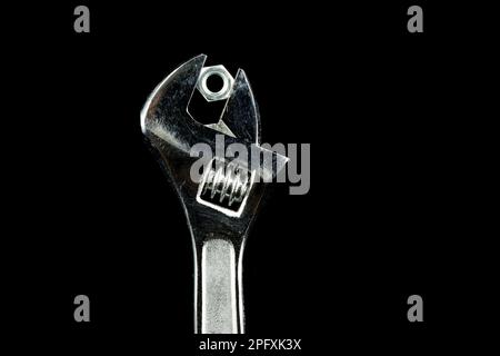 Ols adjustable wrench with nut isolated on black Stock Photo