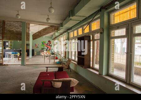 The interior of an abandoned building full of garbage, furniture and glass left by users. Stock Photo