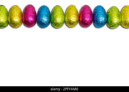 Wrapped chocolate Easter eggs in a row isolated on white. Stock Photo