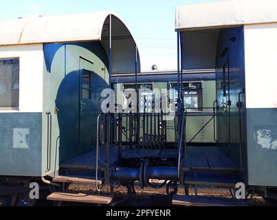 Coupling between two antique train carriages. There is abalcony and a small bridge with a folding balustrade that the conductor and passengers can ste Stock Photo