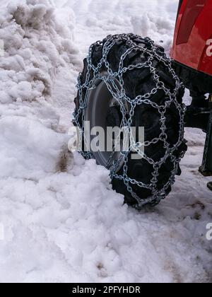 Wheel with snow chains on the vehicle for clearing snowy roads - snow plow. Stock Photo