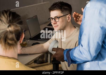 IT Development Team Working on VR Project. Man wearing VR headset, playing and touching something in the virtual world. Diverse men programmers using Stock Photo