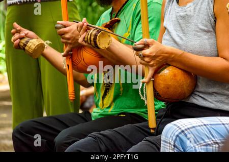 Musicians playing Afro Brazilian percussion musical instruments called berimbau during a capoeira performance in the streets of Brazil Stock Photo