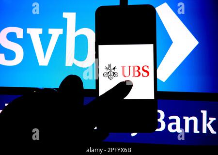 In this photo illustration, an UBS logo is displayed on a smartphone with a Silicon valley Bank(SVB) logo in the background. Stock Photo