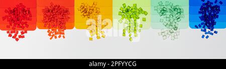 multicolored transparent plastic granulates with its color samples plates on white Stock Photo