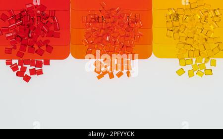 multicolored transparent plastic granulates with its color samples plates on white Stock Photo