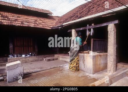 A woman getting water from the well, Nattukottai Chettiar house at Kanadukathan in Chettinad, Tamil Nadu, India Stock Photo