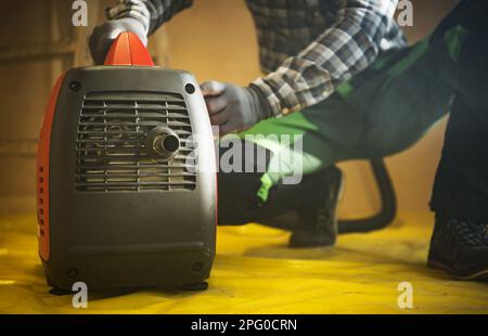 General Construction Worker Preparing Gasoline Electricity Generator To Work Close Up Photo. Stock Photo