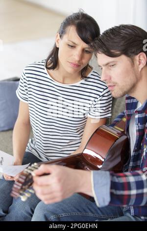 loving couple study to play acoustic guitar together Stock Photo