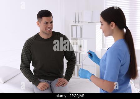 Doctor taking sample for STD testing from man in clinic Stock Photo