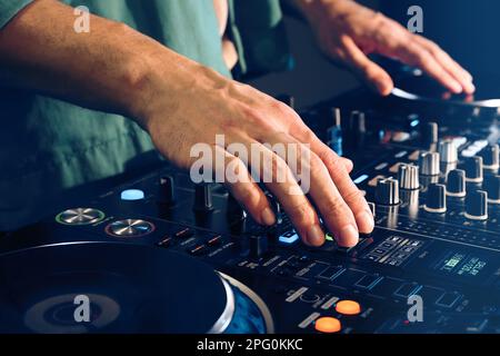 DJ creating music on modern console mixer in night club, closeup Stock Photo