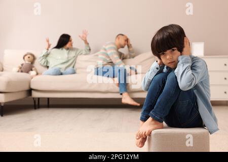 Couple arguing at home, focus on their upset child Stock Photo