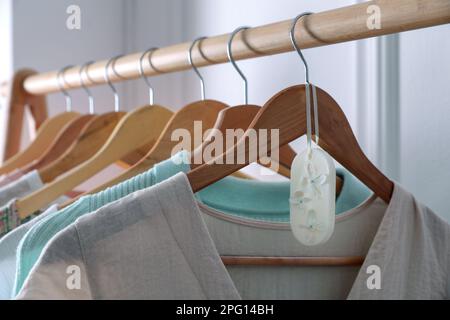 Scented sachet with flowers and stylish clothes on hanger Stock Photo -  Alamy