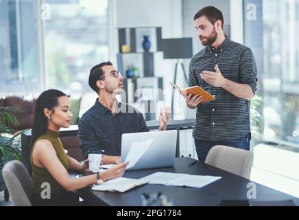Sparking creativity within his team. a young businessman giving a presentation to his colleagues in an office. Stock Photo