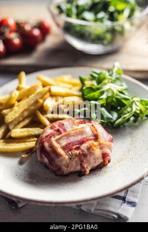 Camembert or brie cheese wrapped in bacon, prosciutto,jamon, or prsut on a plate. Stock Photo