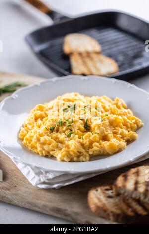 Plate full of freshly-made scrambled eggs for breakfast with griddle-toasted bread. Stock Photo