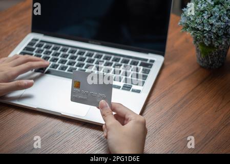 woman using laptop shopping purchasing online, paying by credit card, making payment, checking balance, browsing internet banking service. Stock Photo