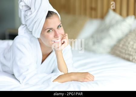 Happy beauty teen after showering lying on a bed posing looking at camera Stock Photo