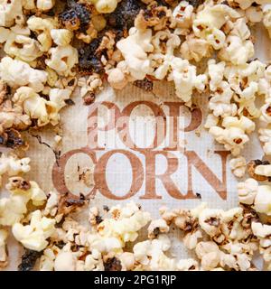 Burnt popcorn from a home microwave. Burn corn kernels on the kitchen table Stock Photo