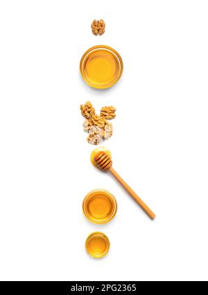 Honey in jars, dipper and nuts on a white background top view. Stock Photo