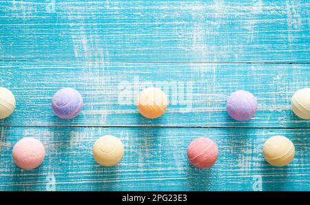 Multicolored bath bombs on a blue wooden background, top view. Stock Photo