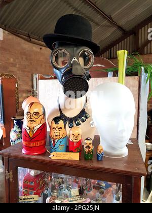 Interior of an antique emporium in Essex, UK showing a mannequin's head with a bowler hat, gas mask and Russian dolls. Stock Photo