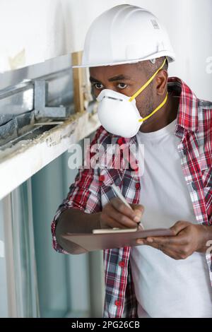 builder male worker in protective mask and helmet Stock Photo