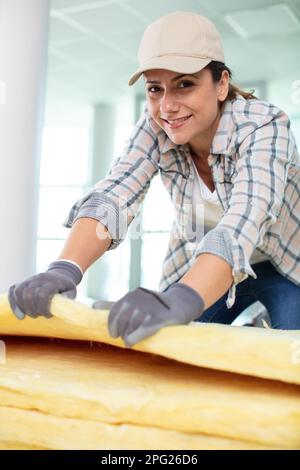 female contractor installing rockwool insulation Stock Photo