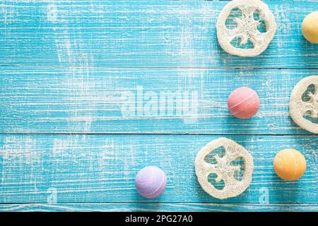 Multicolored bath bombs and loofahs on a blue wooden background. Stock Photo