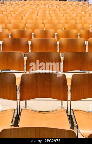 Rows of wooden backed empty seats in a church Stock Photo