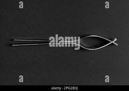 Two kitchen forks together on their side on a dark background. Stock Photo