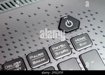 Turn on power key button. Gaming grey notebook keyboard close-up. Tech, IT, electronics, computer science background Stock Photo