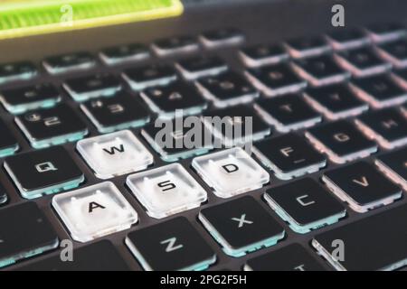Highlighted gaming keys with focus blur. Powerful dark notebook keyboard close-up. Tech, IT, e-sport, computer science background Stock Photo