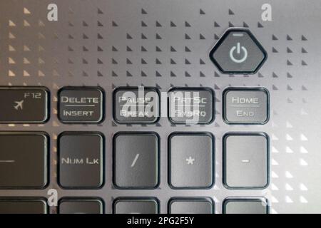 Turn on and off power key button. Gaming grey notebook keyboard close-up. Tech, IT, electronics, computer science background Stock Photo