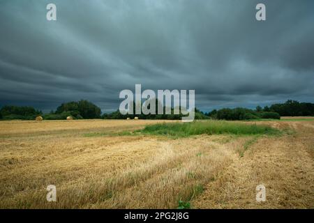 Dark storm clouds over stubble field, summer day, eastern Poland Stock Photo