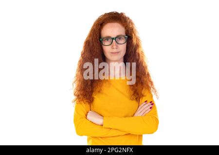 Head shot studio portrait young serious red-headed woman wearing blue t-shirt glasses looking at camera pose on grey white blank, spectacles eyewear o Stock Photo
