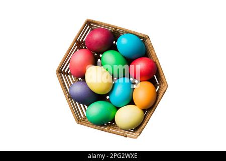 Basket of colorful Easter eggs isolated on white background. Easter basket filled with colored eggs top view holiday concept . Stock Photo