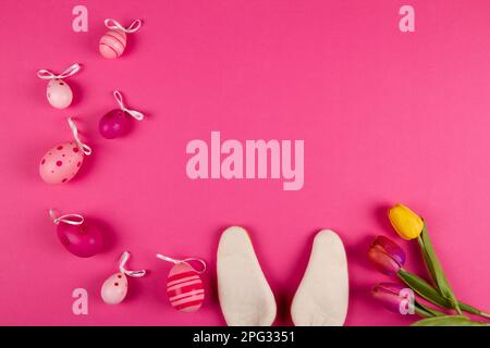 Pink Easter background with copy space, Easter eggs, tulips and bunny ears Stock Photo