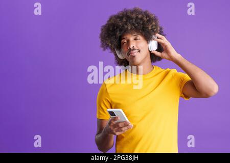 Relaxed african man listening to music with headphones and mobile Stock Photo