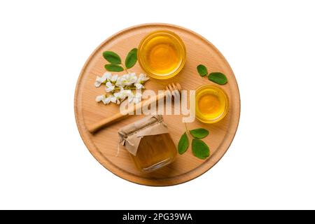 honey jar with acacia flowers and leaves isolated on white background. fresh honey top view flat lay. Stock Photo