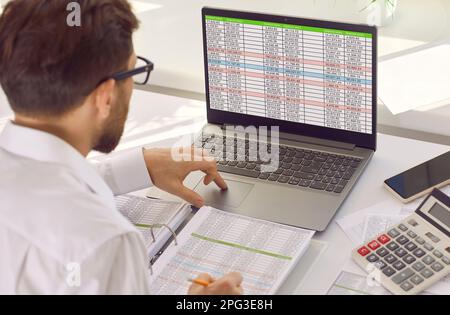 Young man analyst working with spreadsheets in office Stock Photo