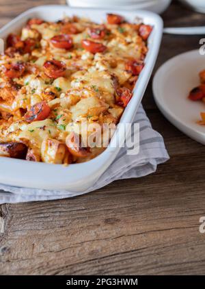 Noodle casserole with salmon, creamy tomato sauce, herbs, and cheese topping. Stock Photo