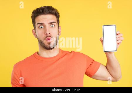 Surprised caucasian man holding a mobile with a blank screen Stock Photo