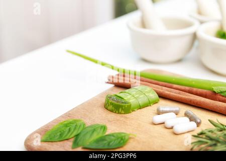 Close up of Herbal medicine preparation with fresh herbs and dried flowers, aromatherapy essential oil and mortar with pestle used in natural alternat Stock Photo