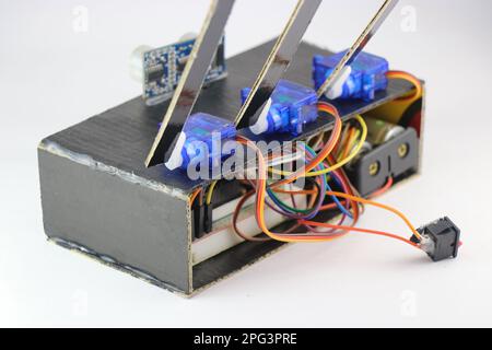 Micro servos or plastic servo motors are connected to a breadboard and microcontroller using jumper wires in an interactive electronics project Stock Photo