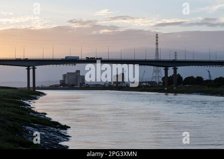 Traffic crosses the River Avon estuary on the M5 motorway's Avonmouth Bridge at dusk in Bristol, England. Stock Photo