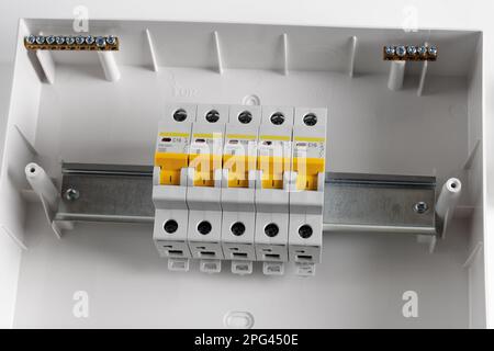 Plastic distribution board. Electrical board. Close-up. Isolated on light gray background. Stock Photo